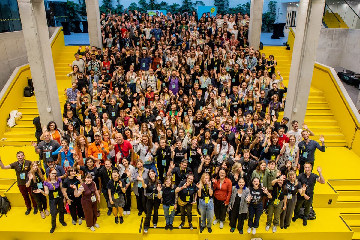 A group photo of conference participants waving to the camera